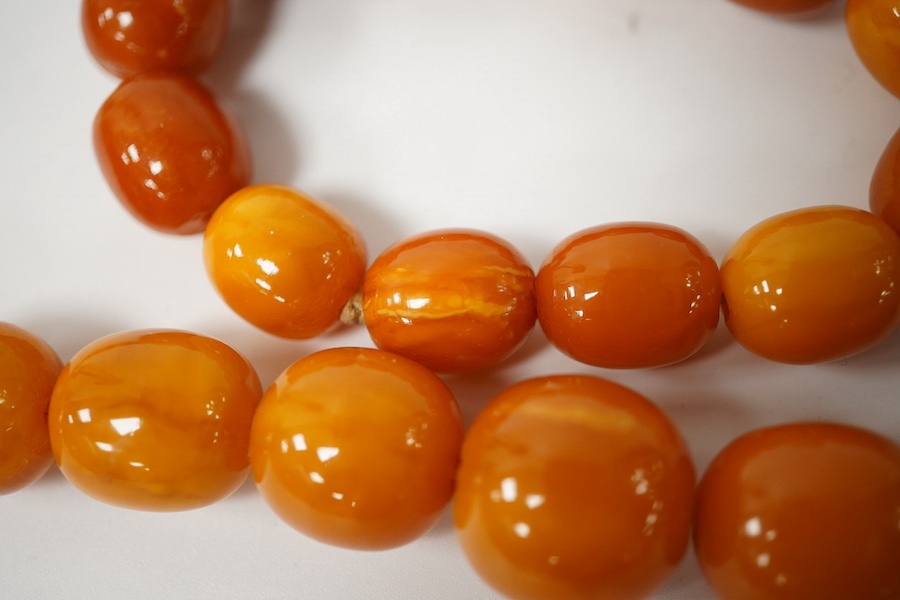 A single strand graduated amber bead necklace, 70cm, gross weight 67 grams, together with an amber bead bracelet, gross weight 20 grams. Condition - poor to fair